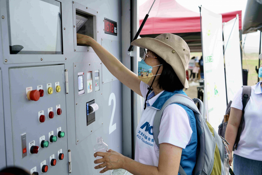 志工們將拾起的寶特瓶投入「好歸塑專車」，讓廢棄塑料空瓶可以直接粉碎、縮小體積，未來將可再製成購物袋、寶特衣、悠遊卡等生活用品